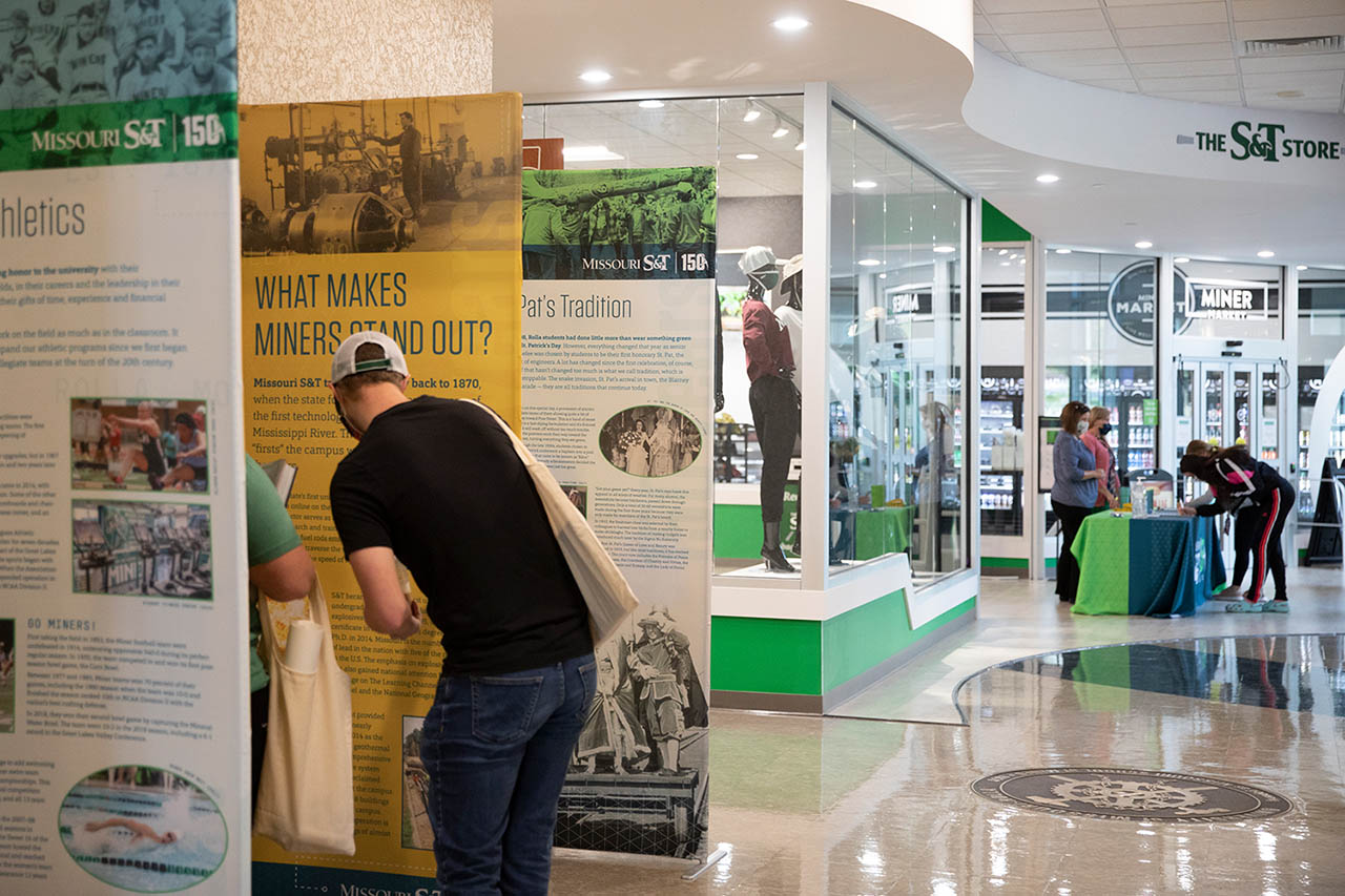 Students standing in hallway looking at popup museum banners.